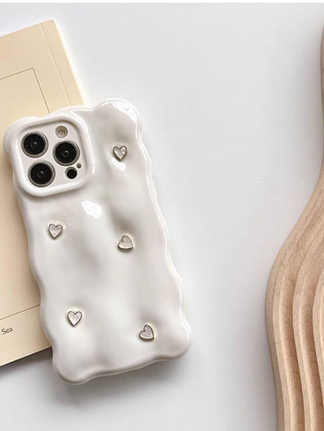 A wavy 3D phone case with heart accents by TALISHKO on a table, showcasing its unique design.