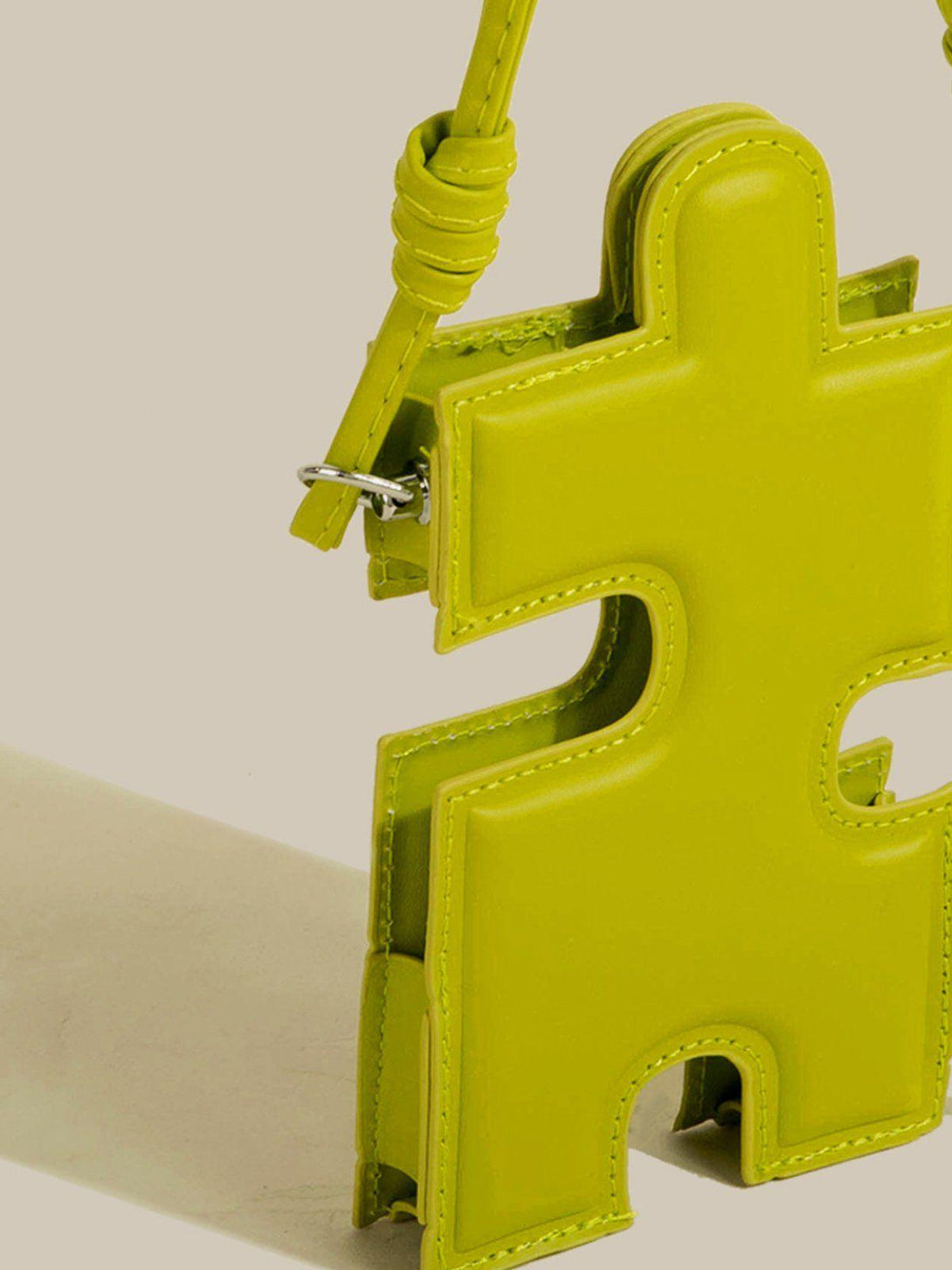 A close-up of TALISHKO's vibrant green puzzle-shaped bag, highlighting its unique silhouette.