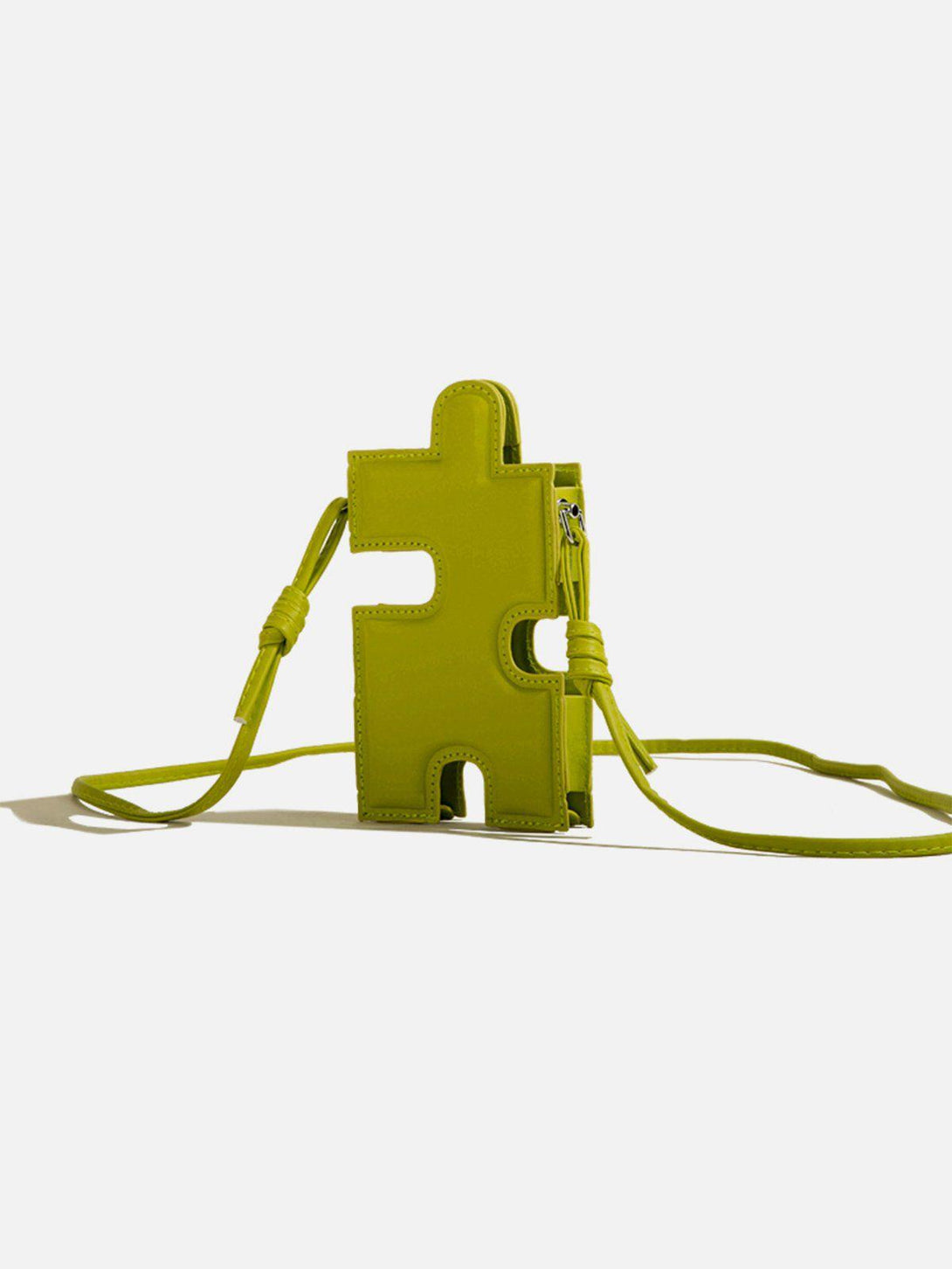 A 3D jigsaw puzzle-shaped bag in bright green by TALISHKO, featuring an eye-catching design.
