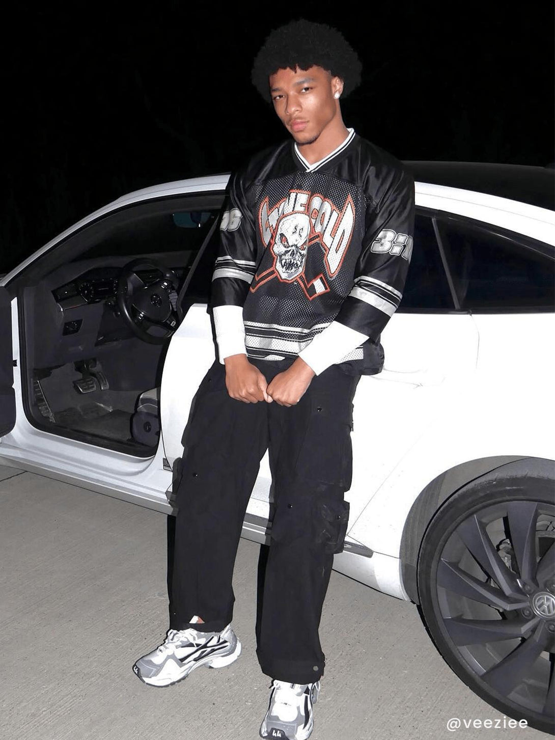 Model wearing TALISHKO's 3D multi-pocket cargo pants, paired with a graphic jersey and sneakers.