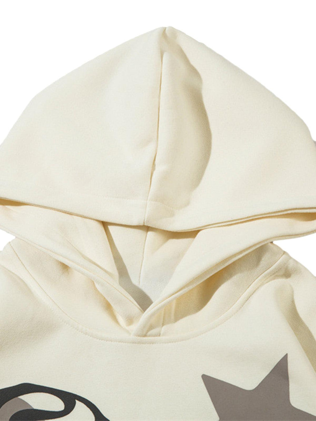 A close-up of TALISHKO's beige pullover hoodie with a unique abstract star design detail.
