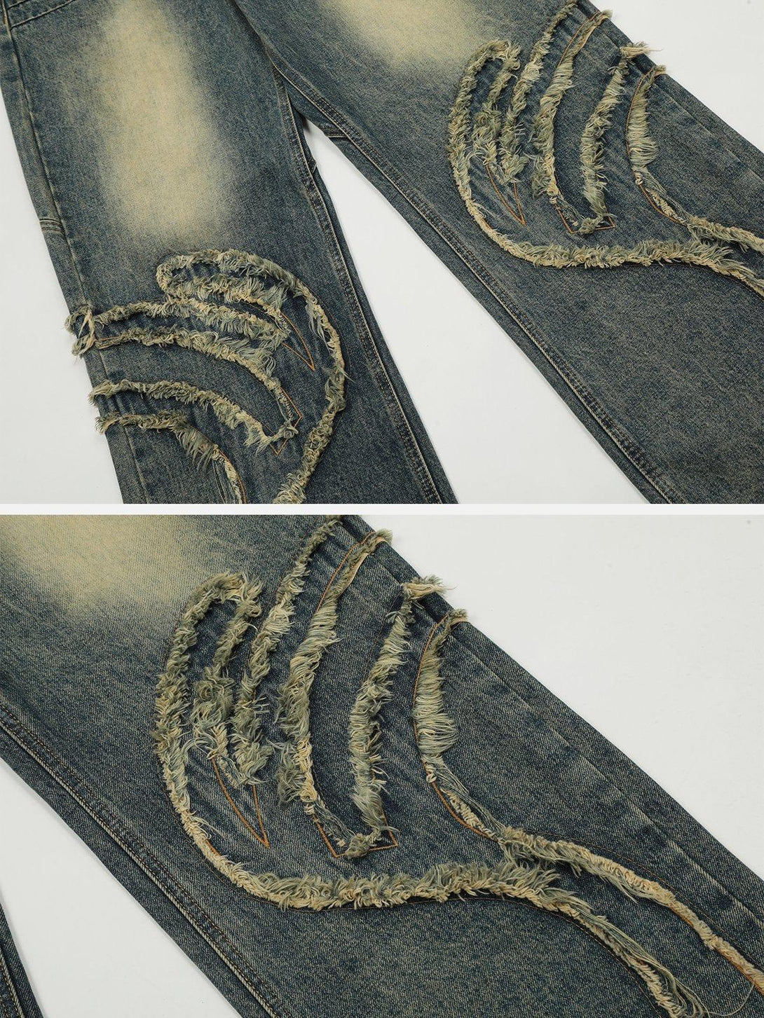 A close look at TALISHKO jeans with abstract pattern and raw edge patchwork detailing.