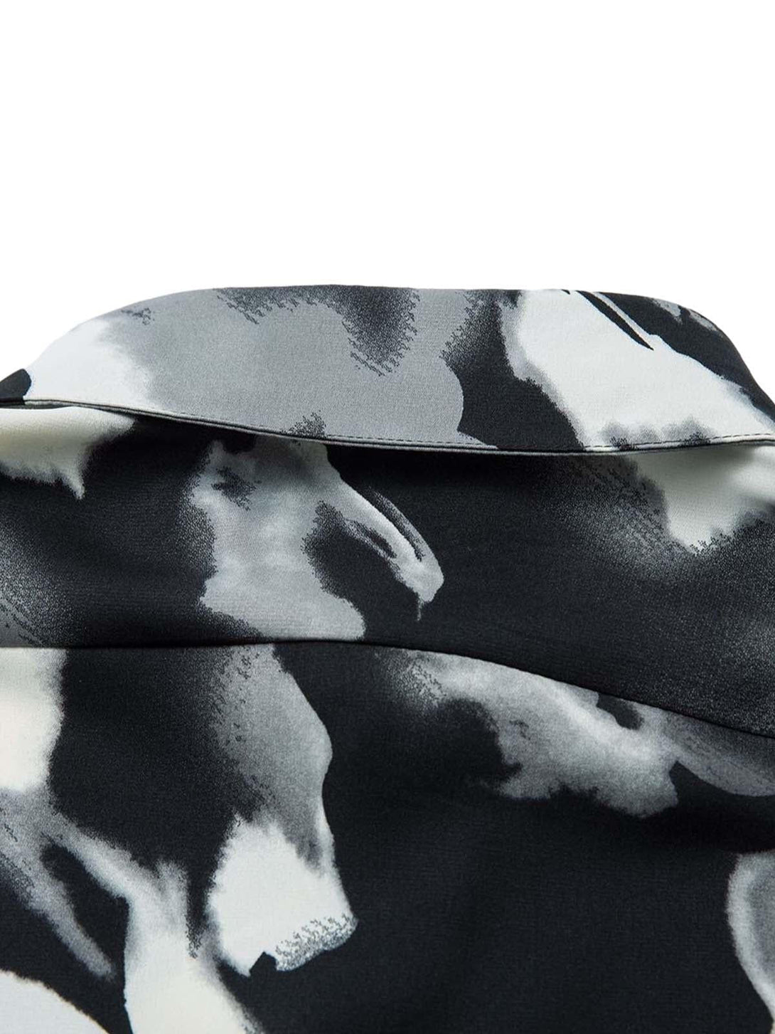 Zoomed-in detail of TALISHKO's abstract tie-dye shirt, showcasing bold monochrome patterns.