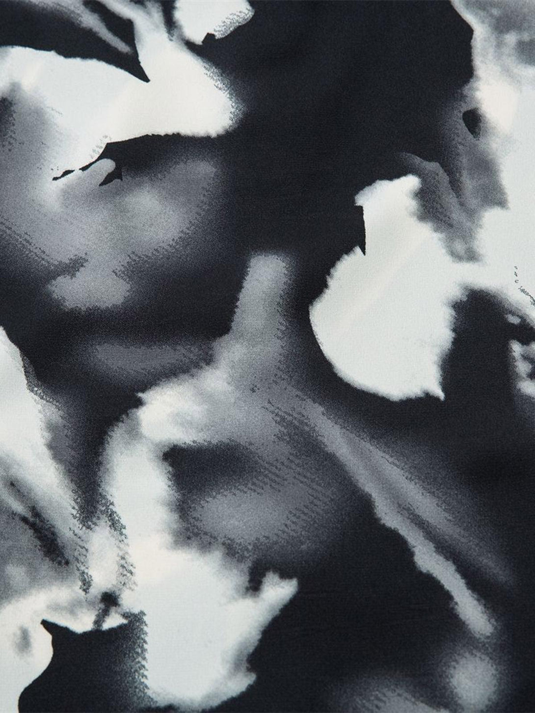 A close-up of TALISHKO's abstract tie-dye shirt, emphasizing its dynamic monochrome design.