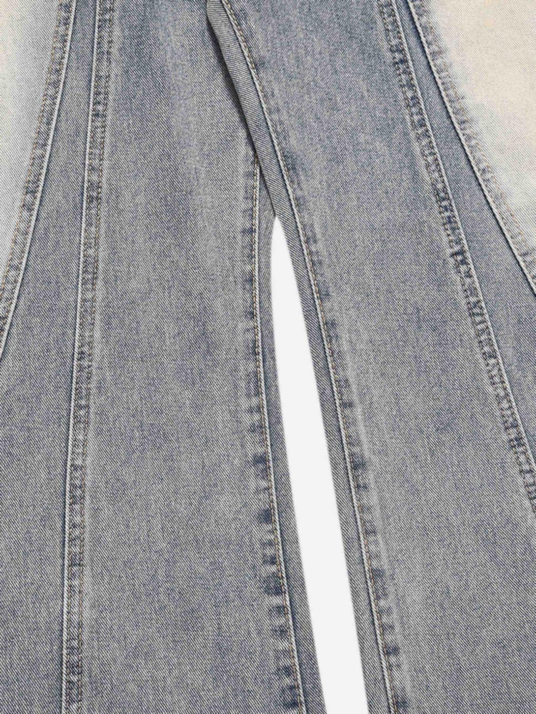 Detailed fabric and stitching of TALISHKO acid wash spray baggy jeans, highlighting texture.