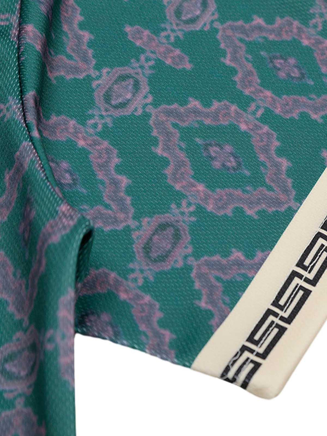 Intricate look at TALISHKO's green patterned jersey fabric, focusing on unique design details.