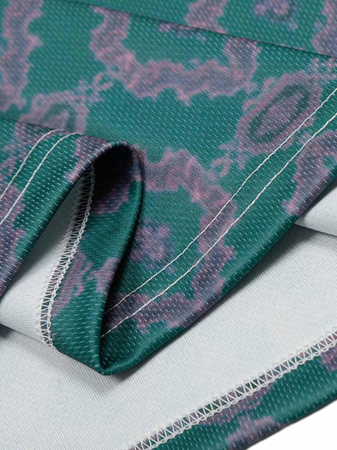 Detailed fabric and stitching of TALISHKO's green patterned jersey, capturing unique style.