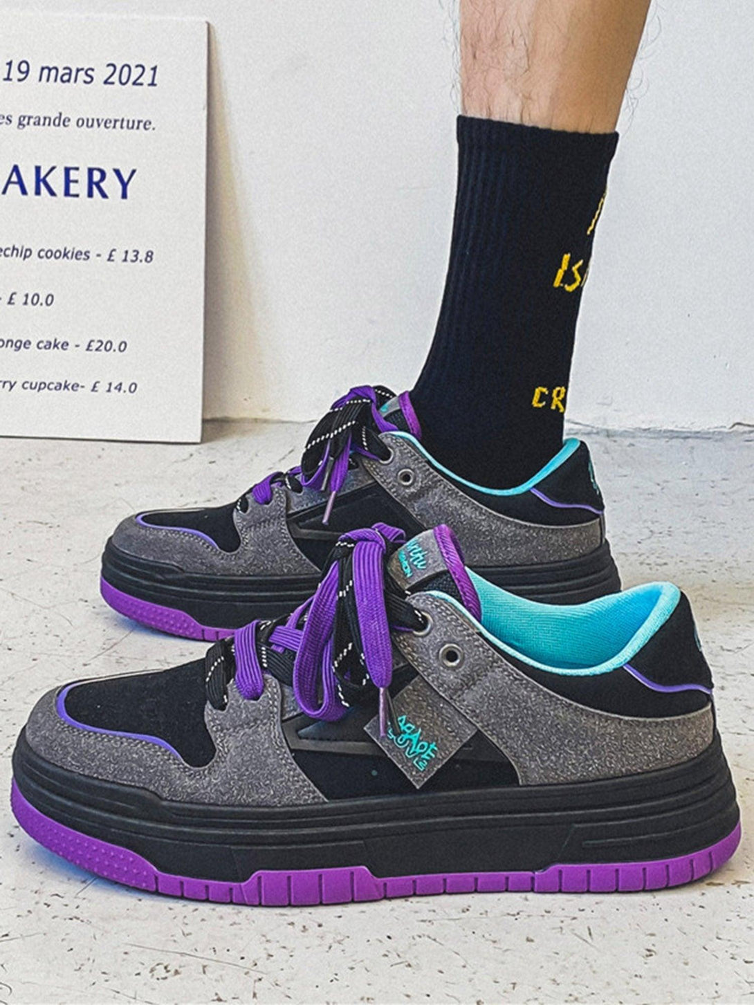 TALISHKO sneakers in gray with purple accents, paired with black socks for a modern look.