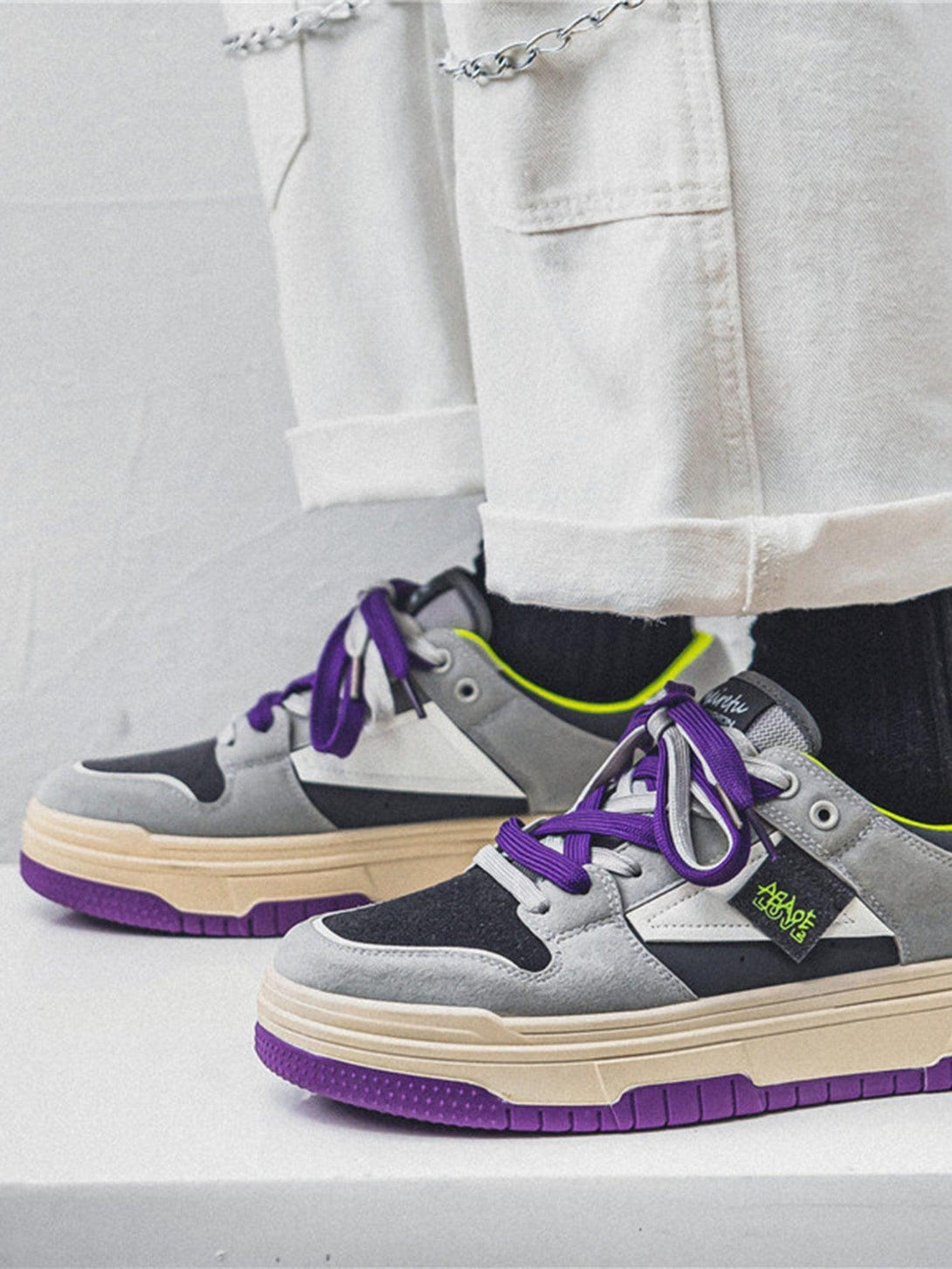 TALISHKO sneakers showcase bold contrasting colors with vibrant purple laces and soles.