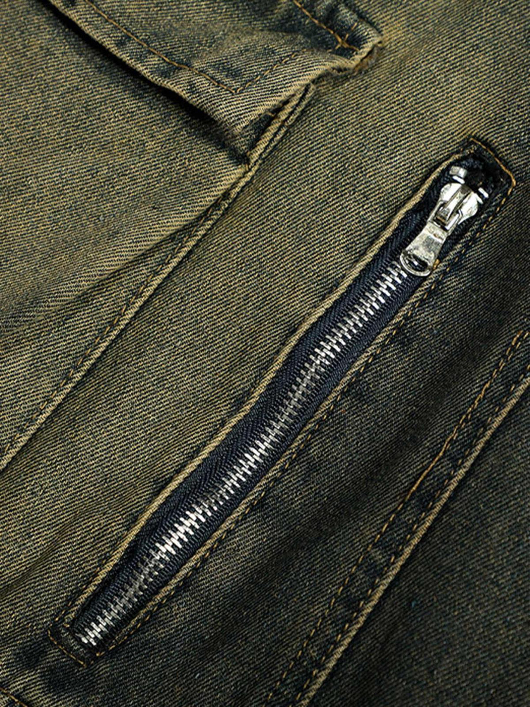 A close-up of TALISHKO's jeans pocket, highlighting the zipper and distressed fabric detail.