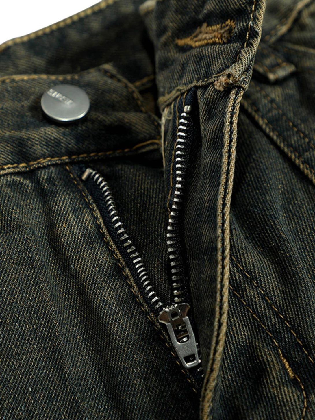 A detailed view of TALISHKO's washed jeans zipper and stitching, highlighting retro design.