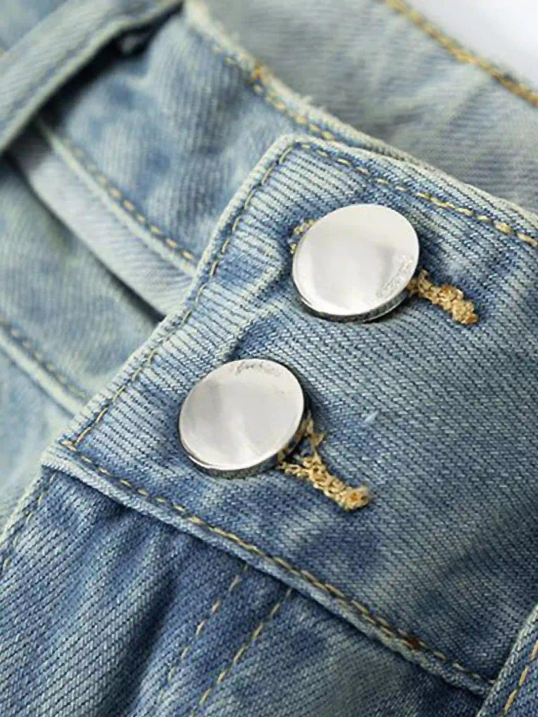 Detailed view of TALISHKO jeans buttons, highlighting vintage denim texture and craftsmanship.