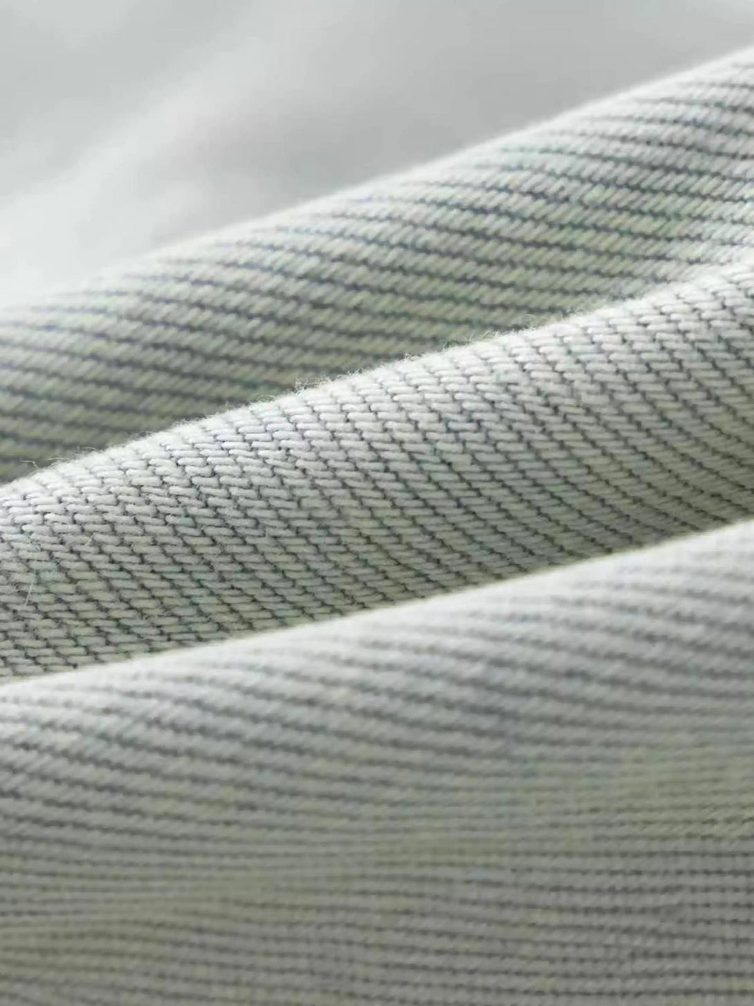 Zoomed-in texture of TALISHKO vintage jeans, showcasing intricate gradient bleach wash.