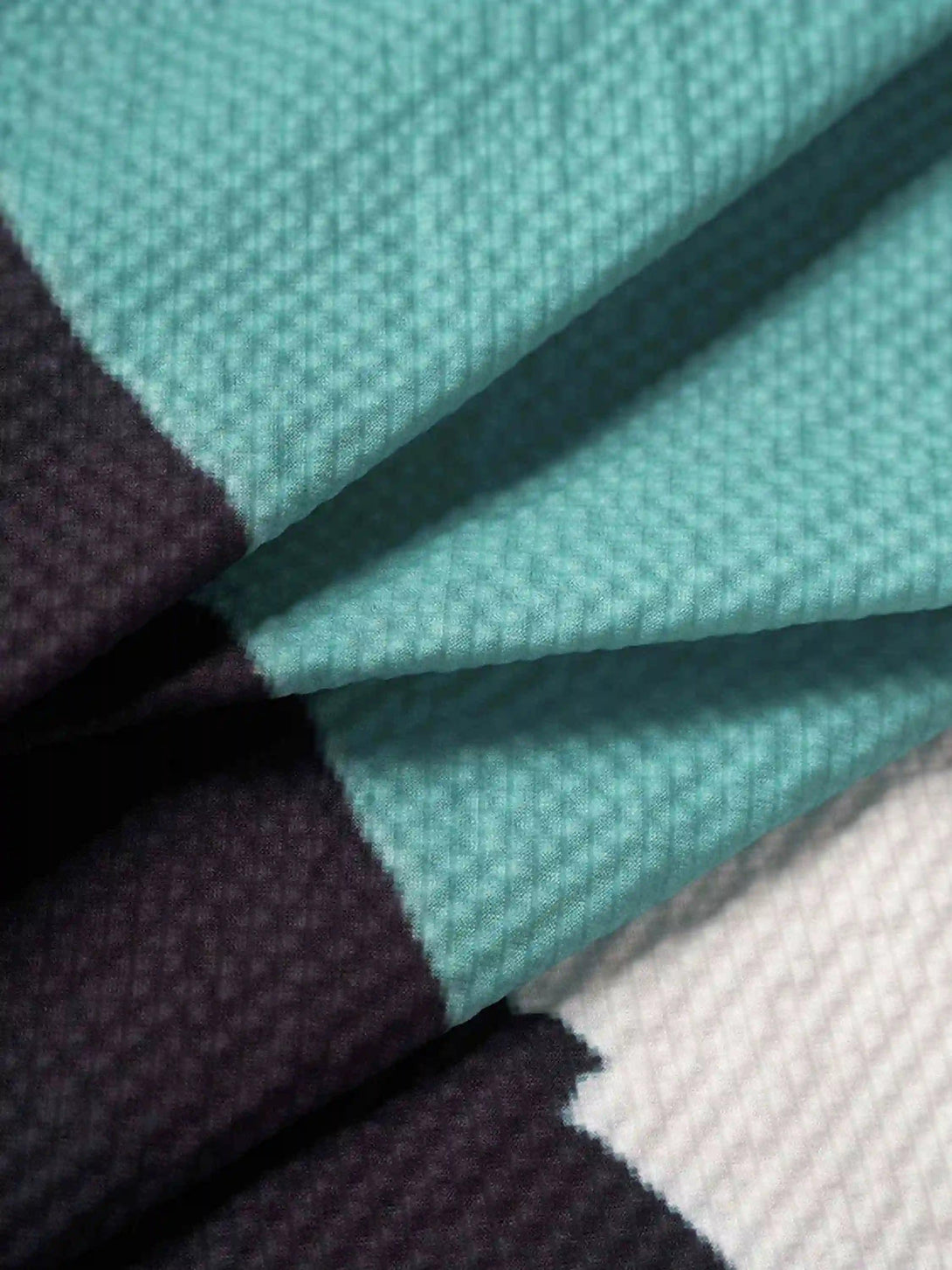Zoomed-in texture of TALISHKO's seersucker shirt, showcasing vibrant abstract patterns.