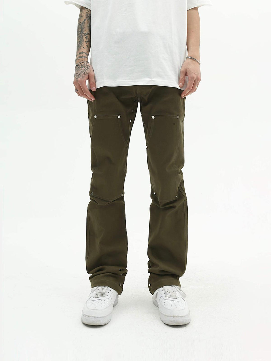 Front view of olive jeans by TALISHKO, featuring unique detailing and paired with white sneakers.