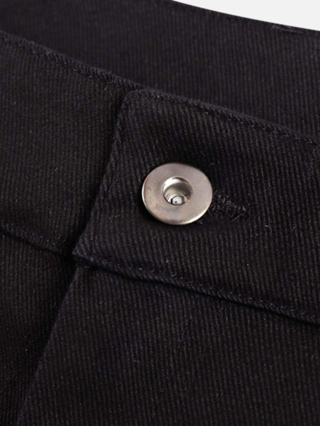Intricate look at the metal button detail on black jeans, highlighting TALISHKO craftsmanship.