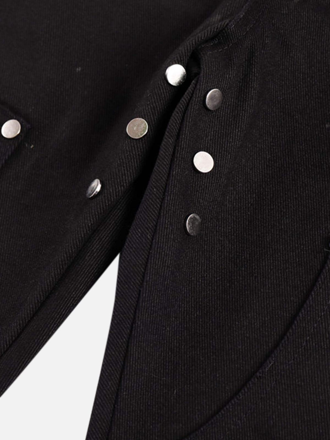 Zoomed-in view of black jeans with metal studs, showcasing detailing by TALISHKO.