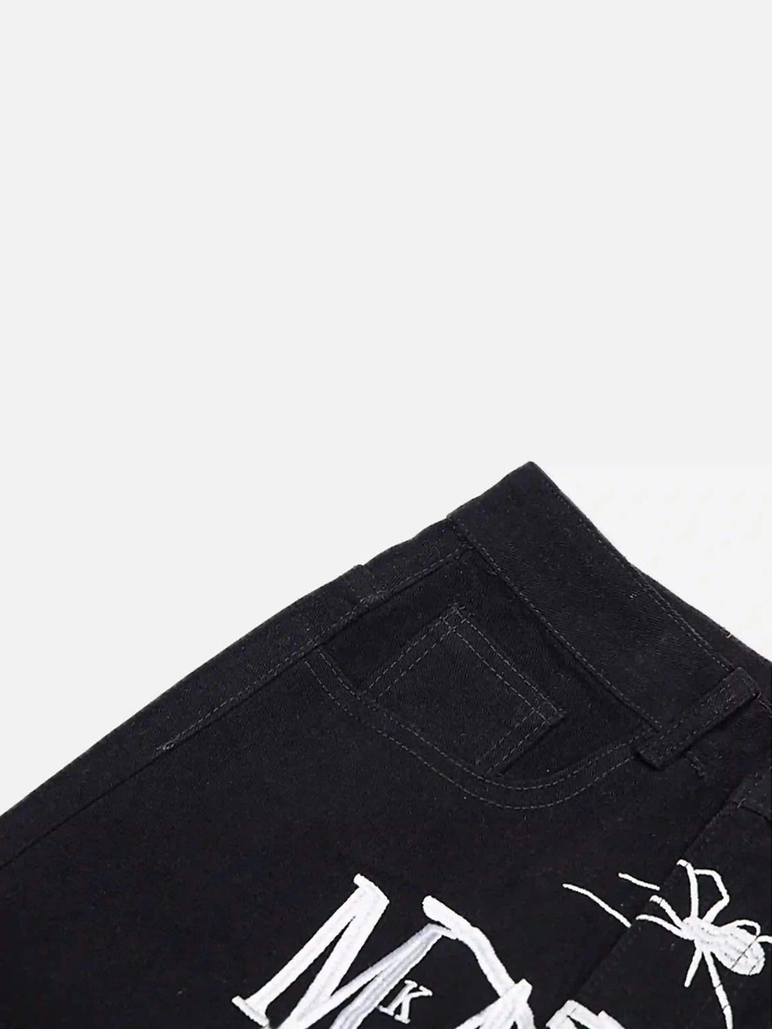 Intricate look at TALISHKO's black jeans with bold spider embroidery, perfect for unique flair.