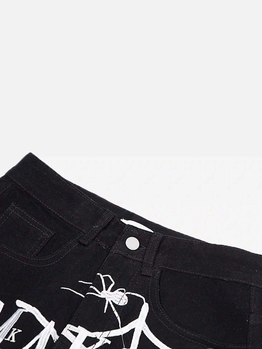 TALISHKO black jeans with intricate spider embroidery detail, highlighting edgy street style.