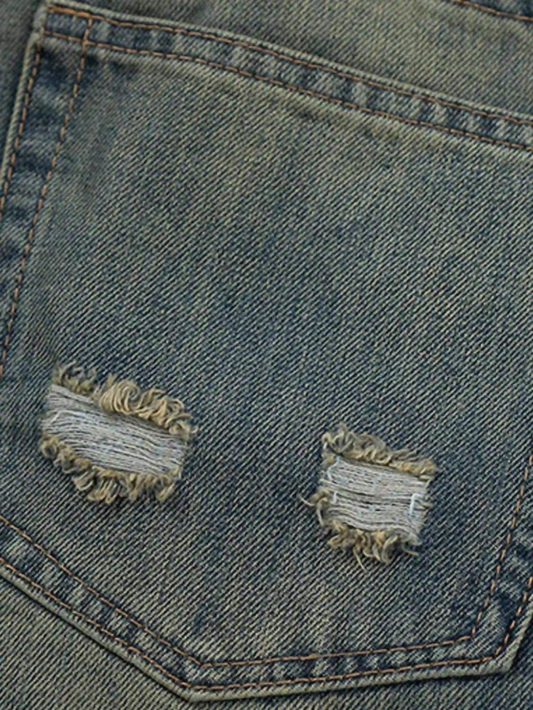 A detailed view of the distressed pocket on TALISHKO's graffiti washed jeans.