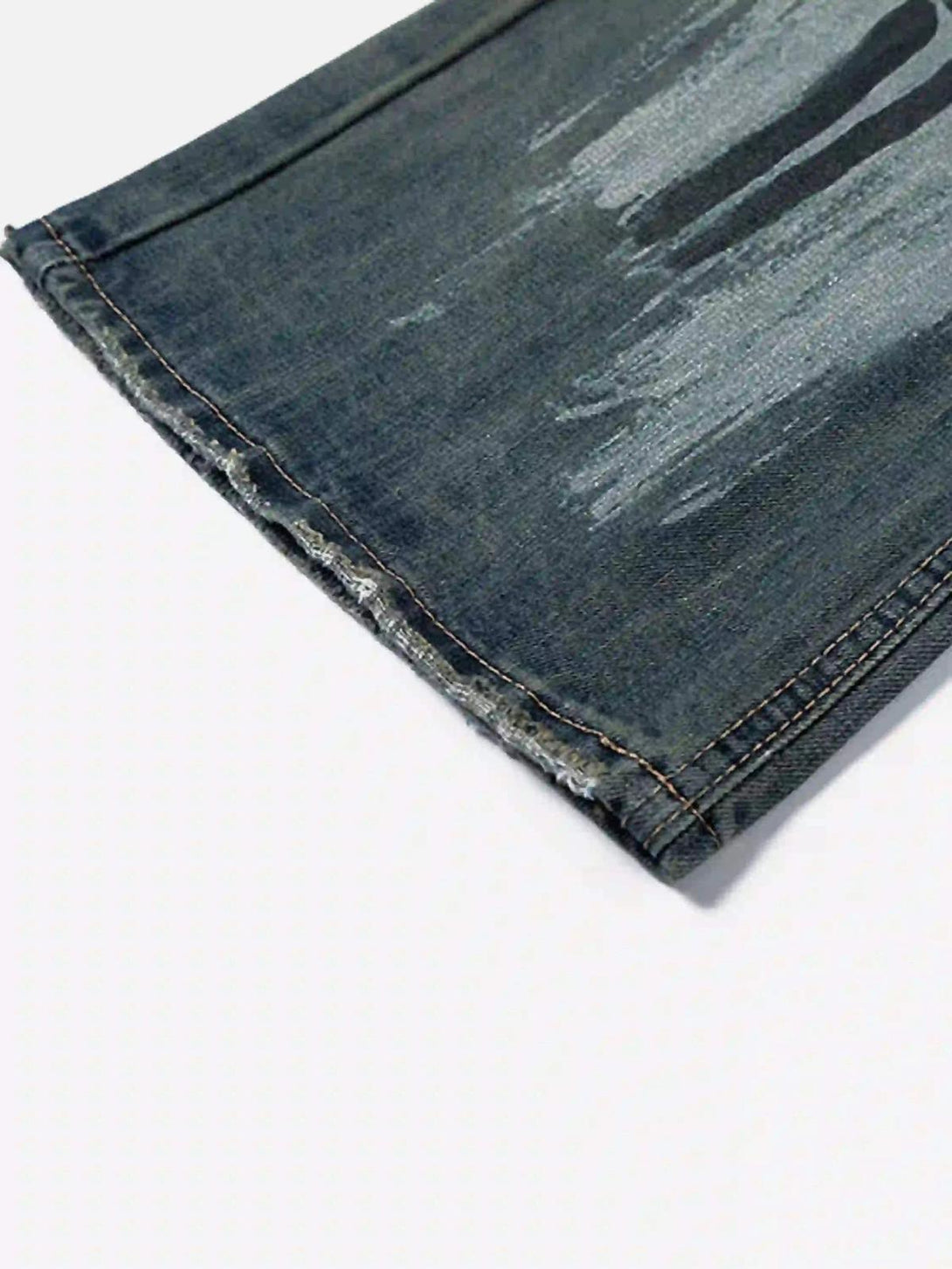 Detailed fabric and stitching on TALISHKO's graffiti washed jeans, highlighting the artistic wash.