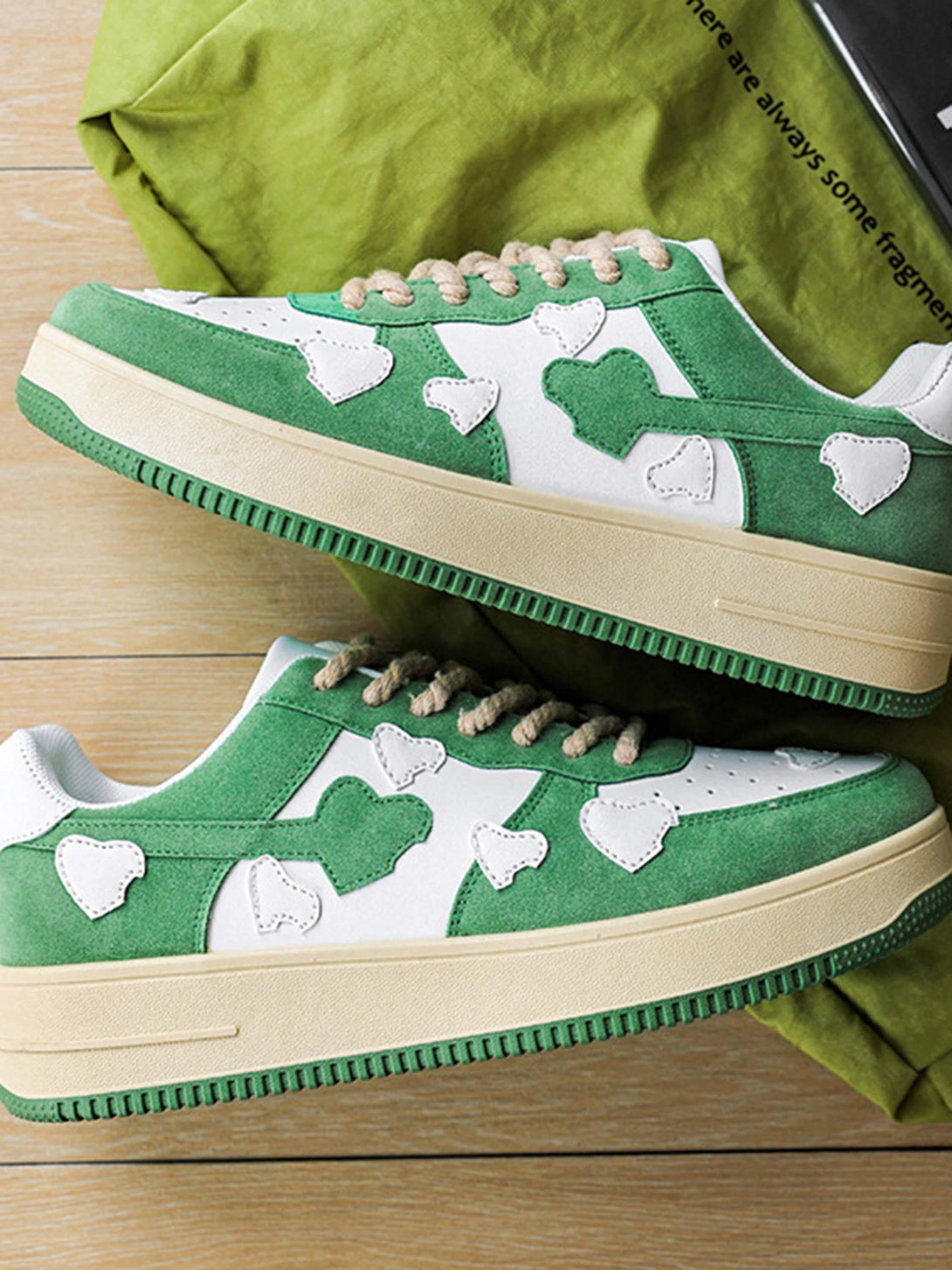 Green retro sneakers by TALISHKO with heart patterns and textured laces, side view.