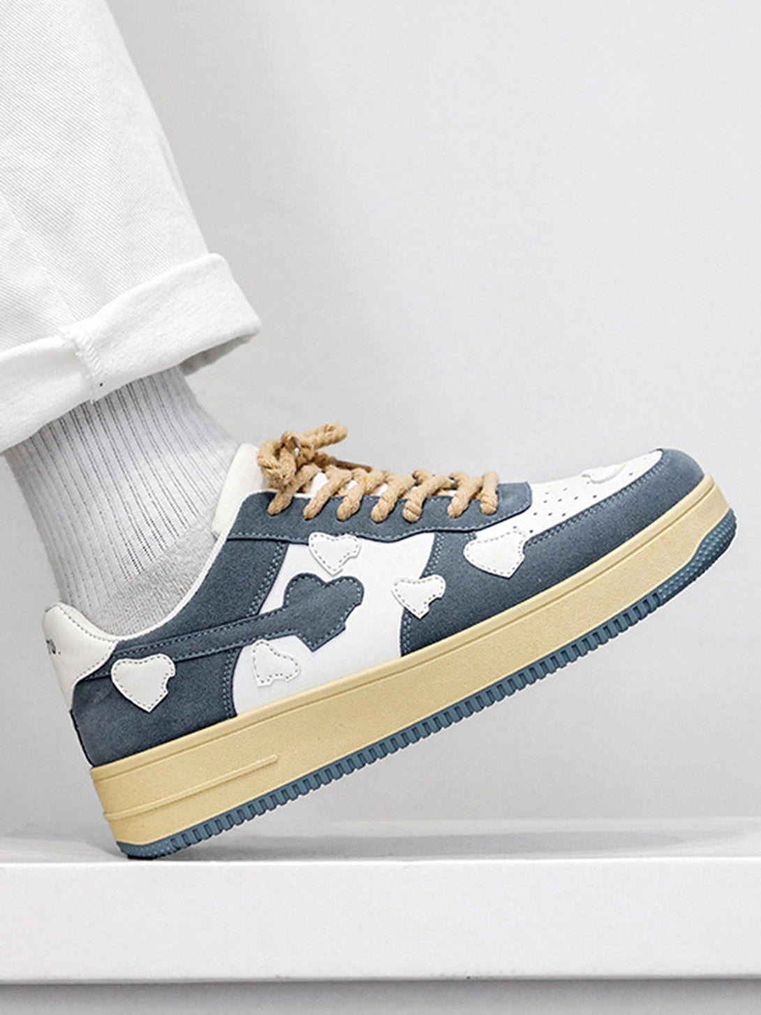 Side view of TALISHKO retro casual sneakers with blue and white heart patterns and textured laces.