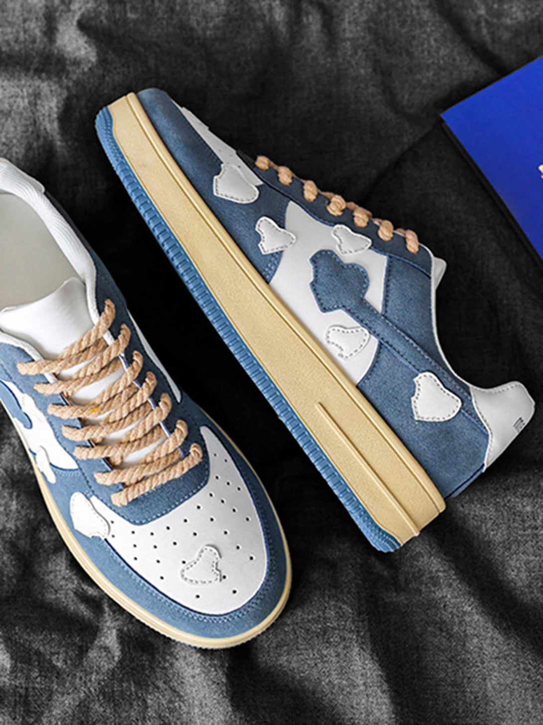 Retro blue and white sneakers by TALISHKO with heart patterns and rope laces, side view.