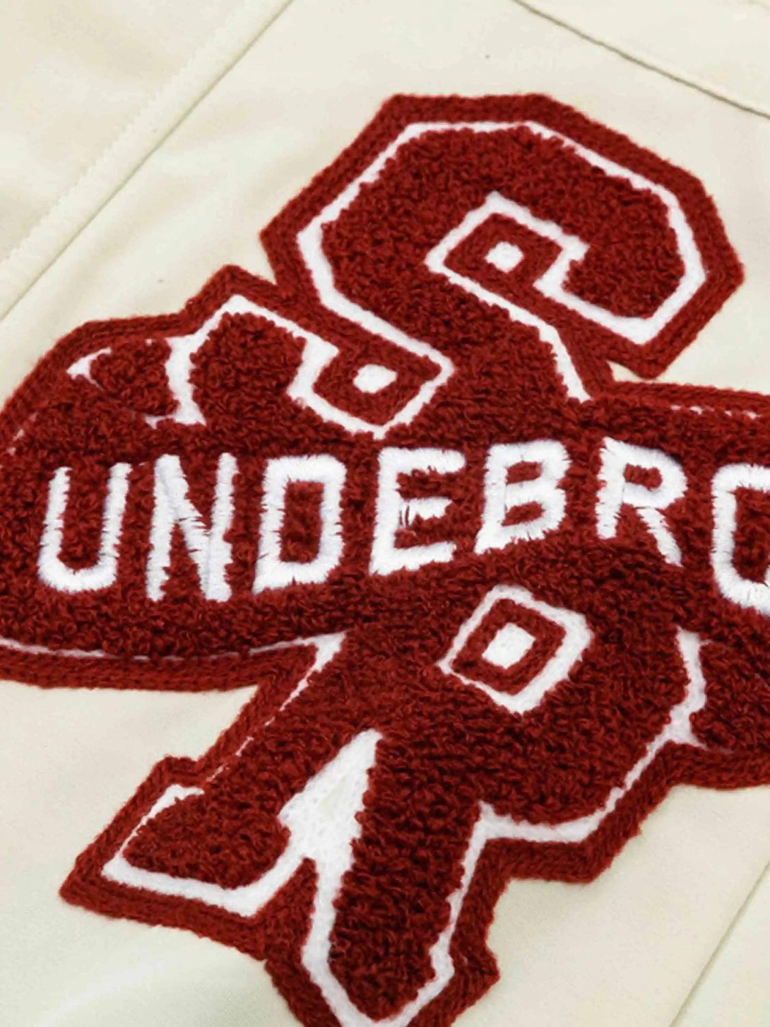 Detailed view of TALISHKO's varsity patch embroidery on a jacket, emphasizing hip-hop vibes.