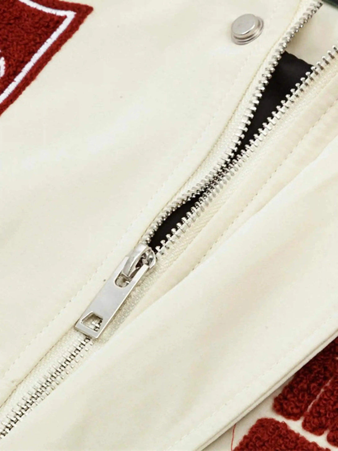 Detailed zipper and button view on TALISHKO's baseball jacket, highlighting hip-hop style.