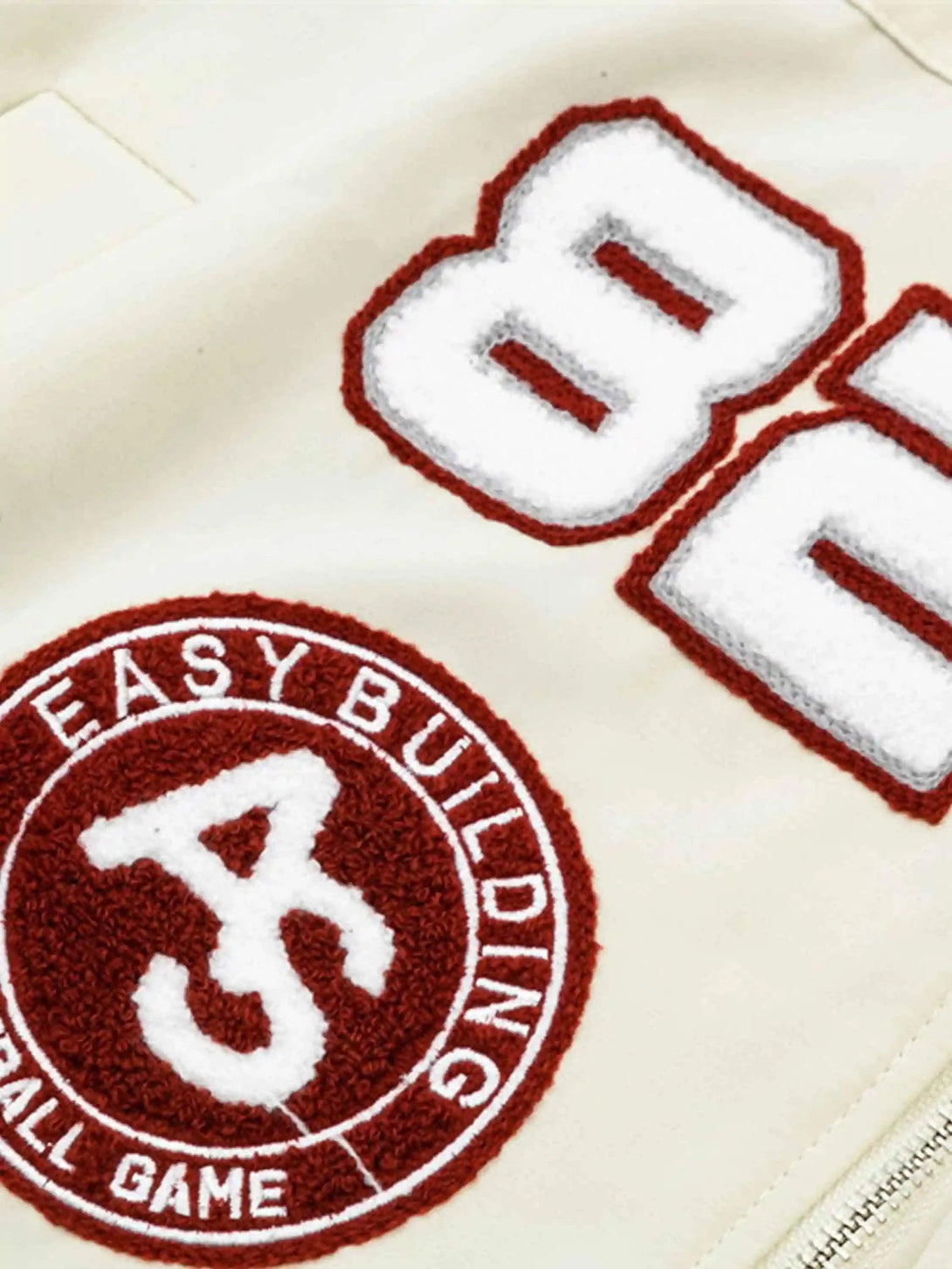 Intricate embroidery details on TALISHKO's baseball jacket, highlighting hip-hop campus style.