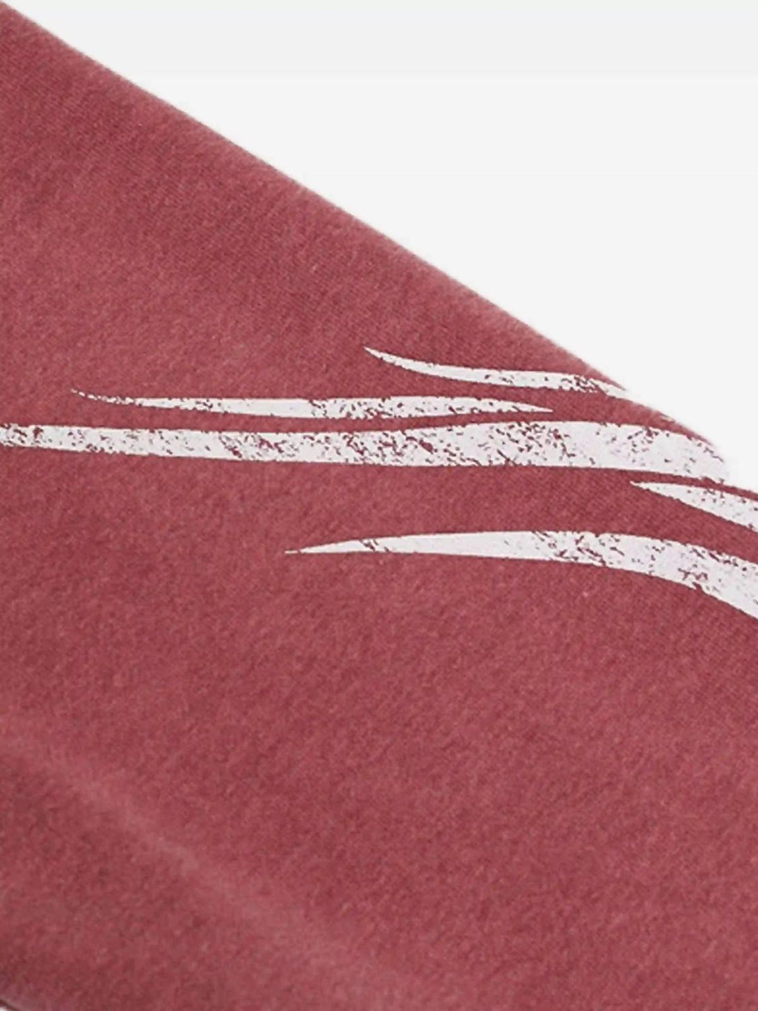 Intricate look at the distressed texture on a red TALISHKO hoodie, featuring graffiti accents.