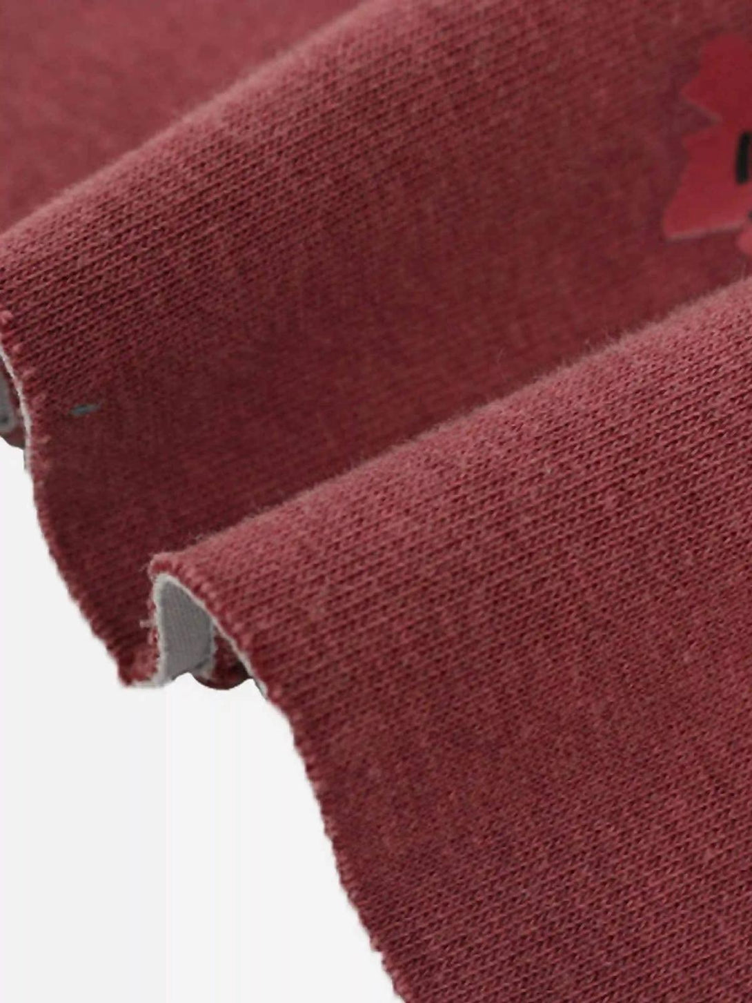 A detailed view of the red TALISHKO hoodie fabric, showcasing its soft texture and quality.