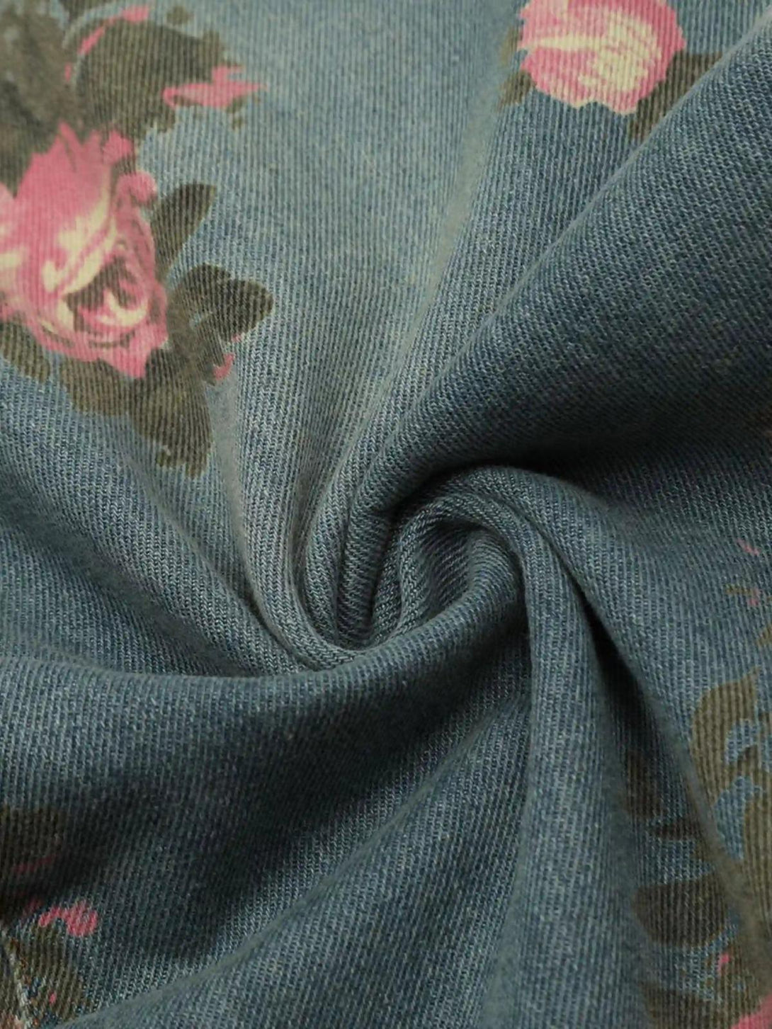 Zoomed-in texture of TALISHKO's vintage jeans, highlighting the floral rose pattern on denim.