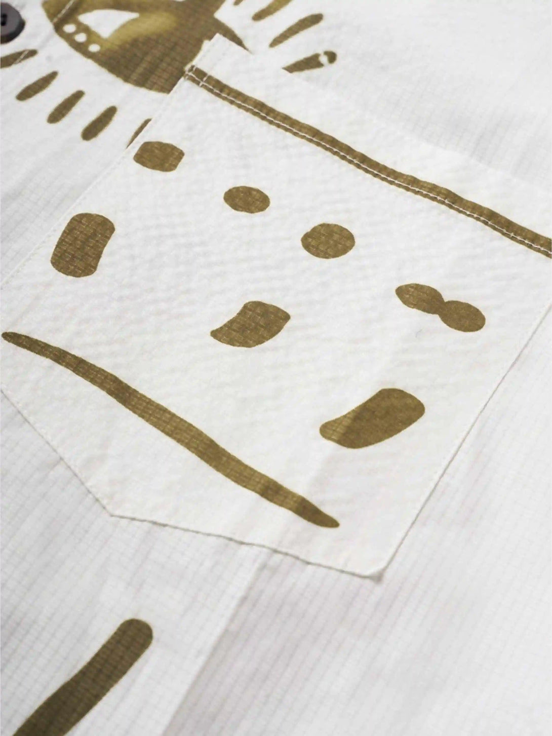 Detailed fabric and stitching of TALISHKO shirt with abstract Mayan-inspired patterns.