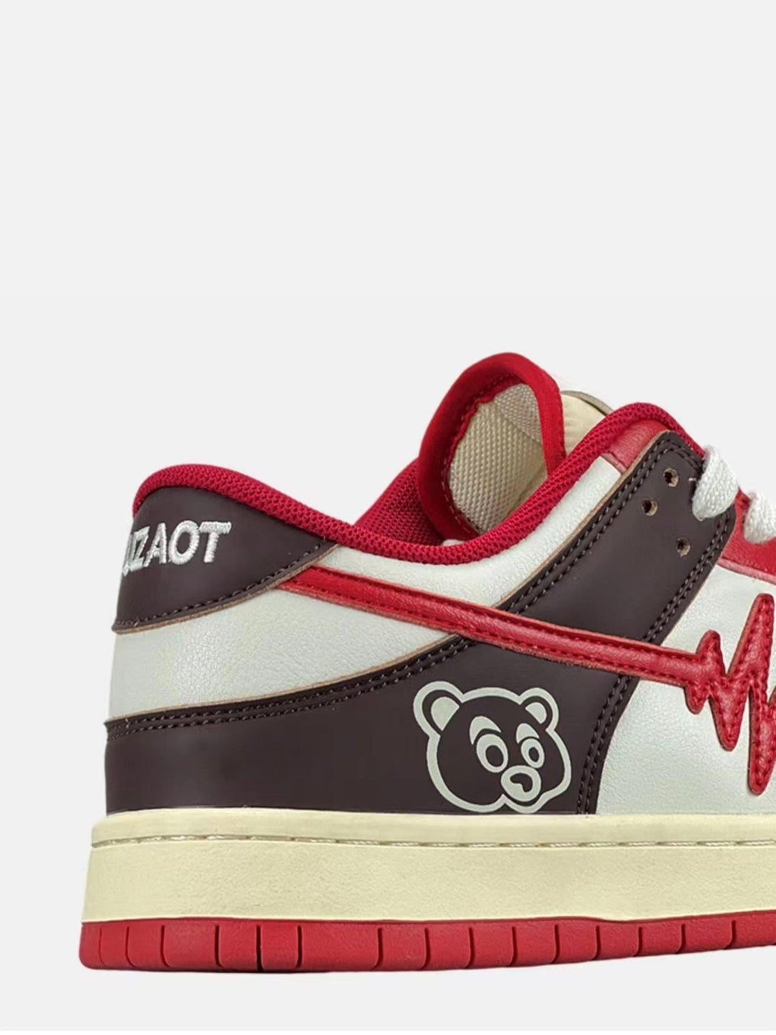 Side view of TALISHKO retro sneakers in red and brown with bear graphic detailing.