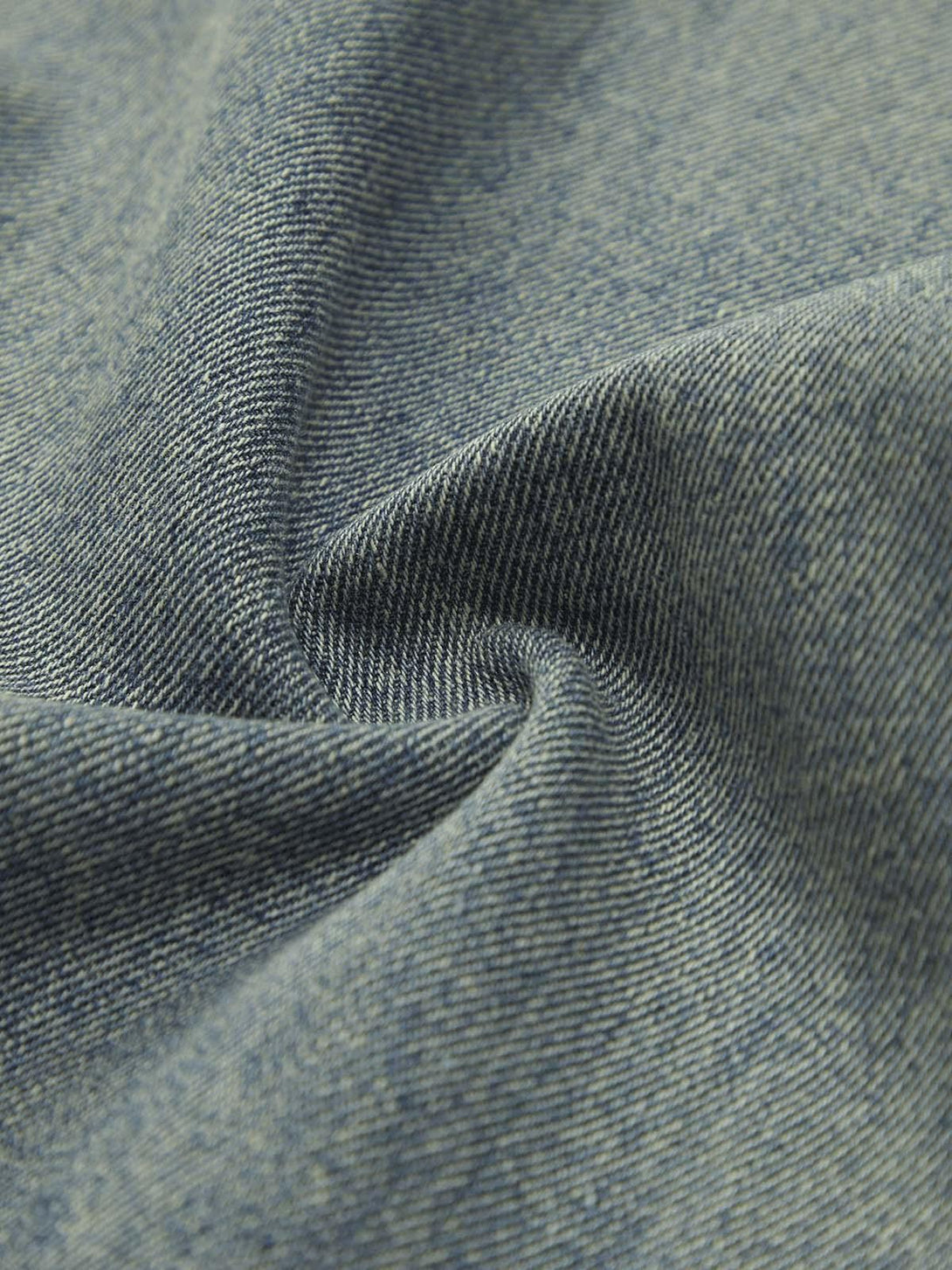 Zoomed-in texture of TALISHKO's retro washed jeans, showcasing intricate fabric details.