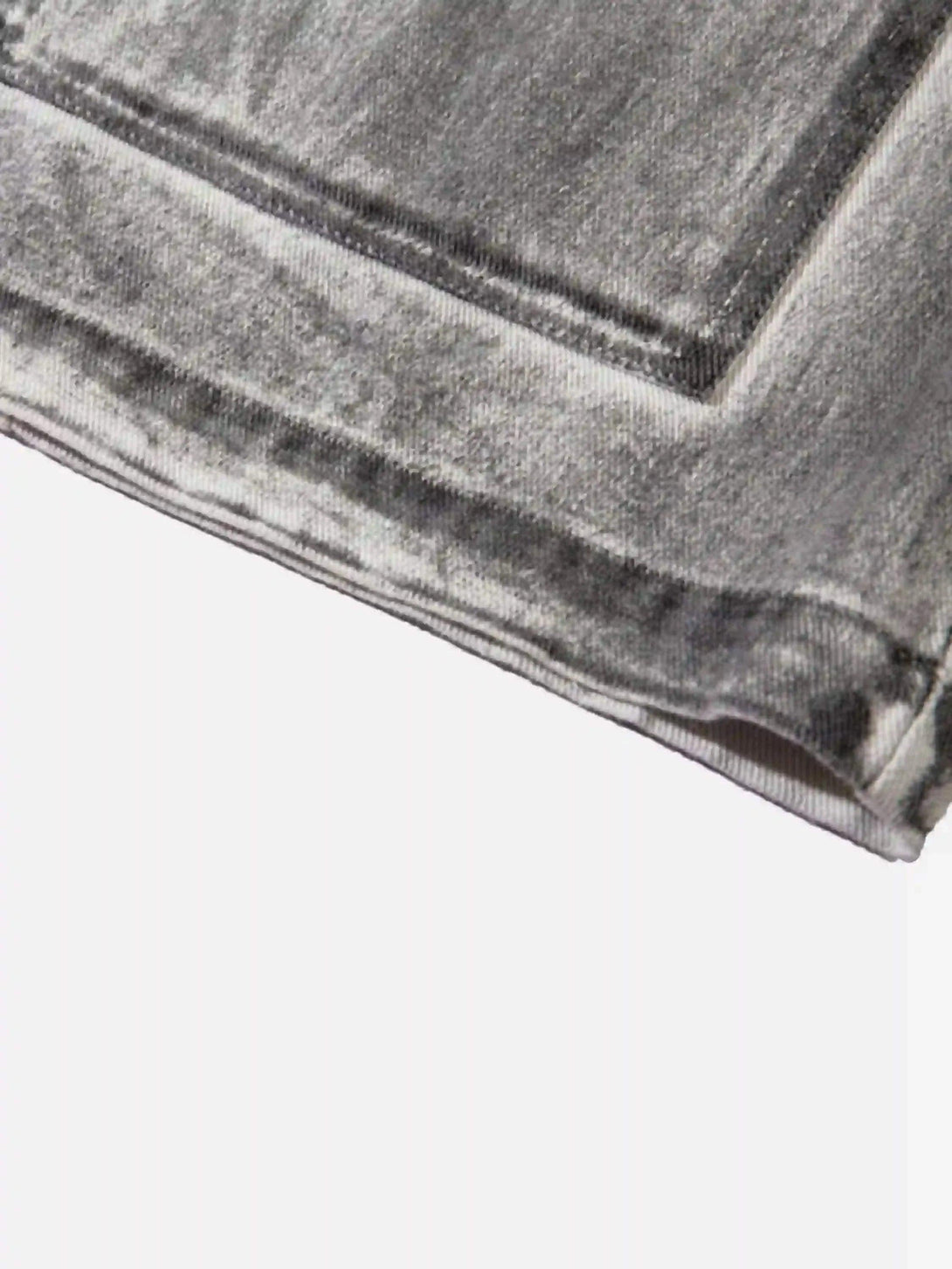 Focusing on the distressed texture of TALISHKO's cargo shorts, highlighting rugged style.