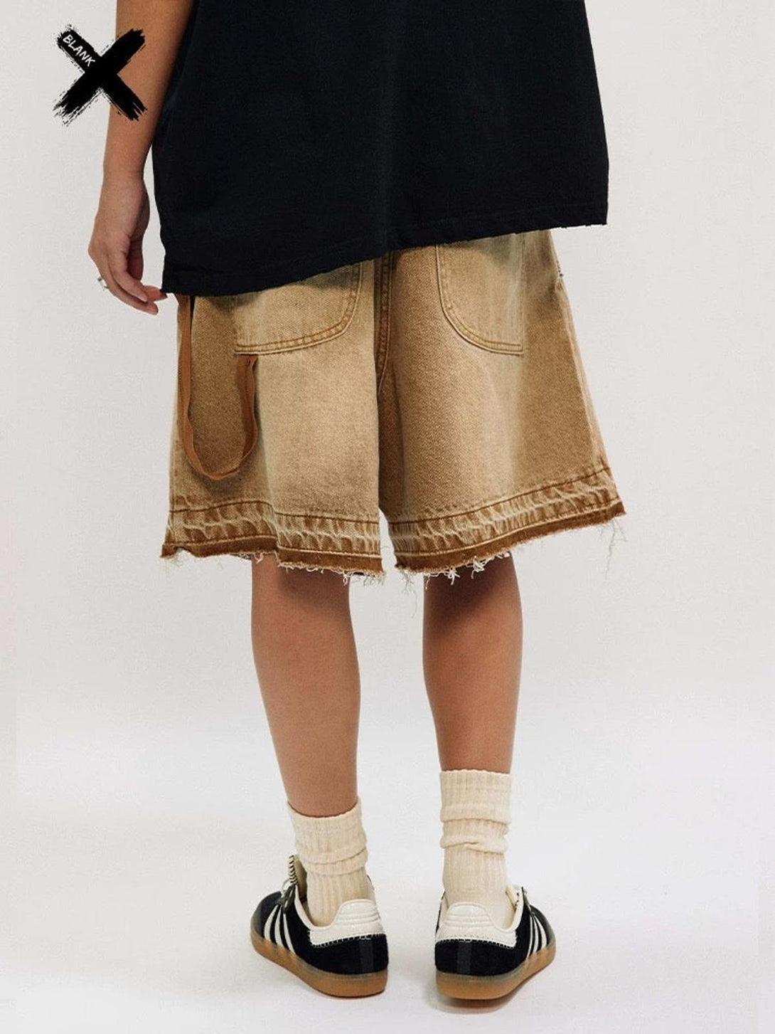 Back view of TALISHKO's distressed denim shorts, paired with sneakers for a casual vibe.