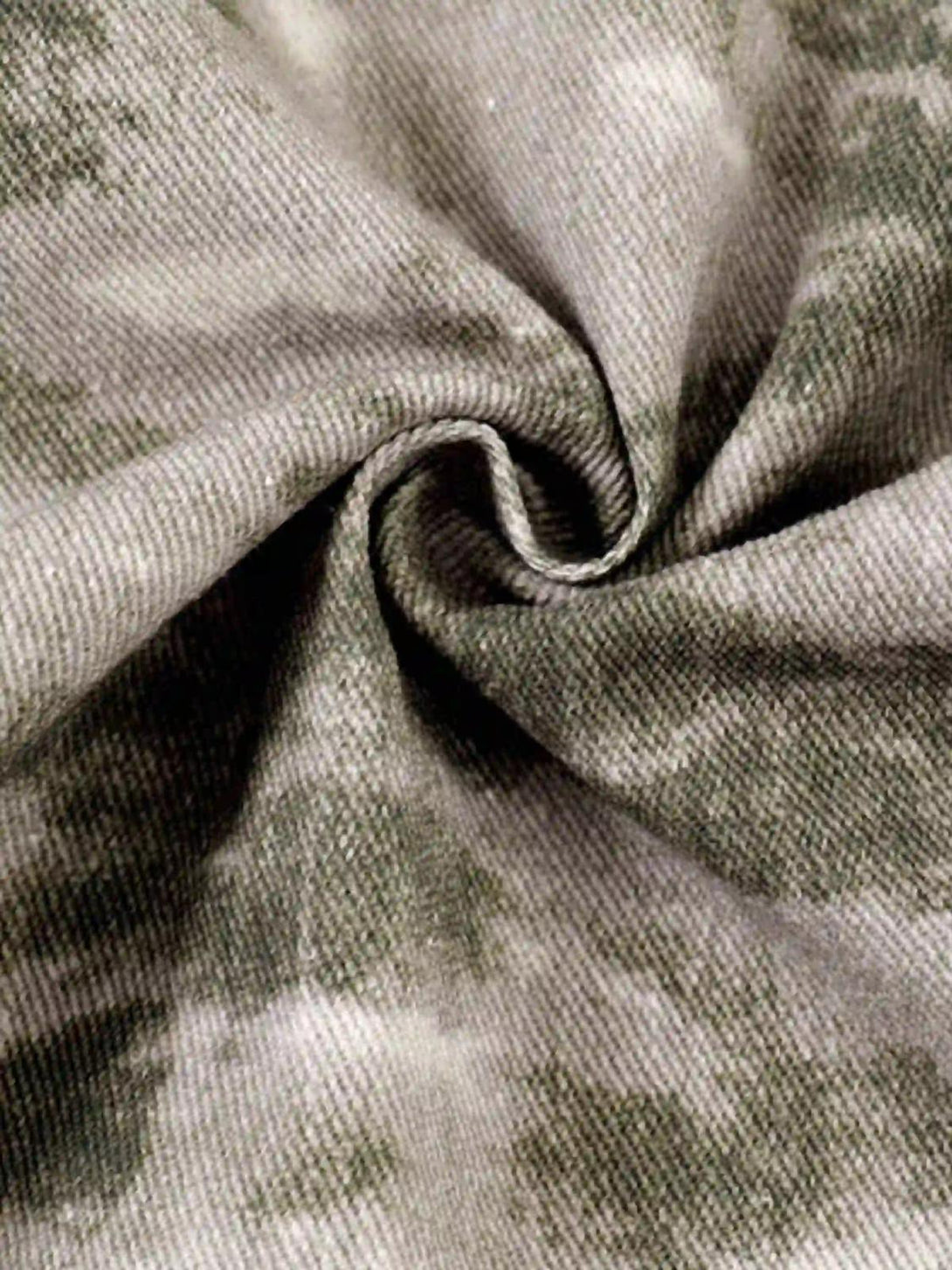 Zoomed-in texture of TALISHKO's flared pants, highlighting the unique camouflage design.