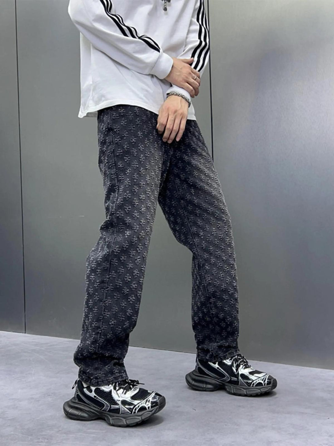 Model wearing TALISHKO jeans with a retro floral design, paired with a sporty top and sneakers.