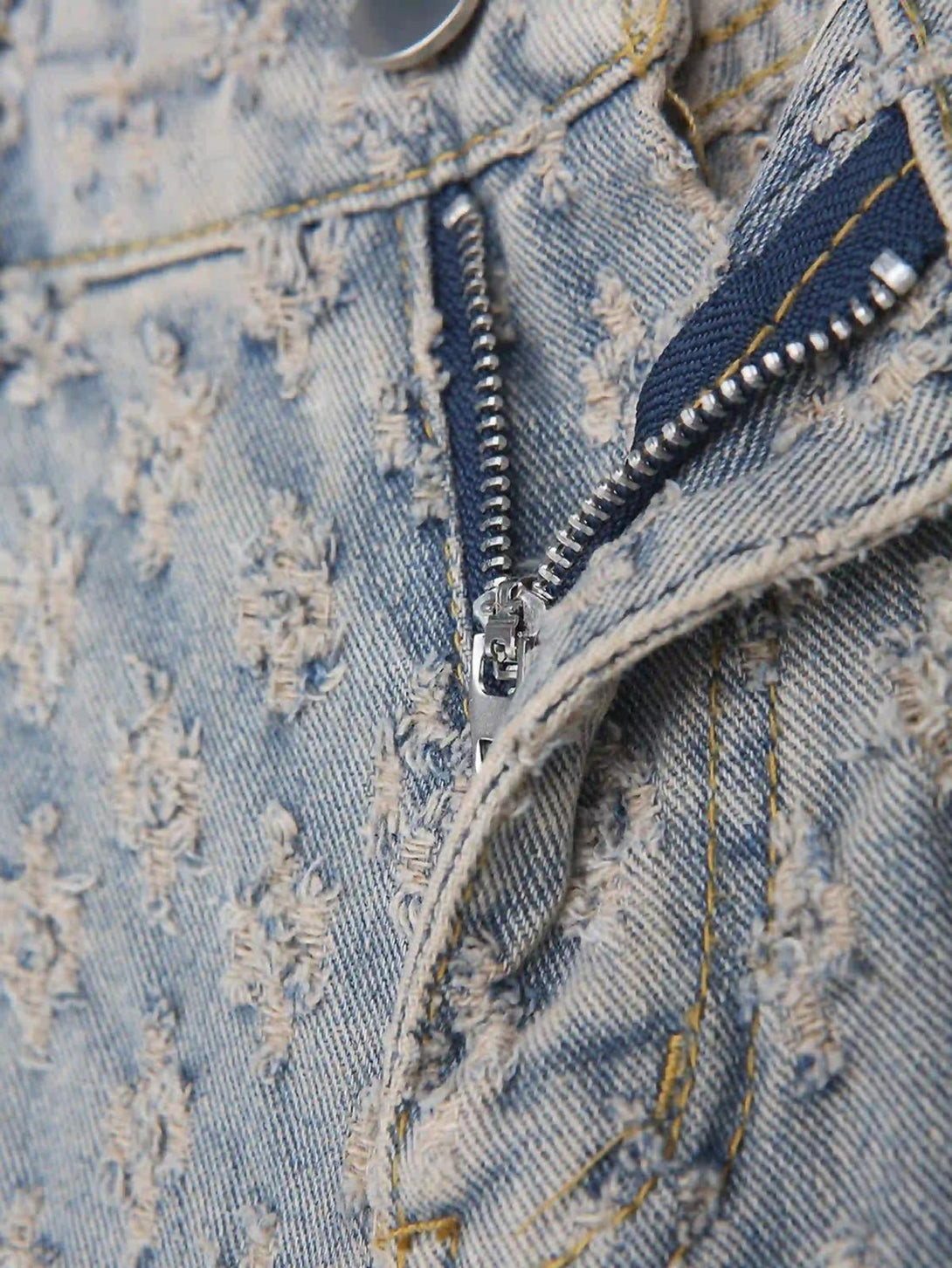 Intricate look at TALISHKO jeans' retro floral texture and zipper detail, highlighting unique design.