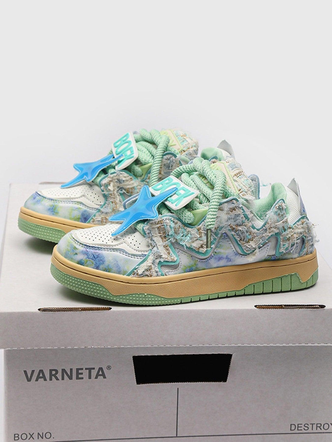 TALISHKO retro sneakers with blue star accents and textured pastel details on a shoe box.