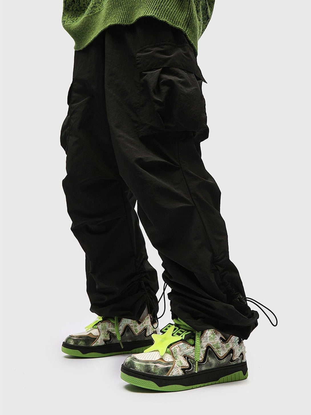 High street TALISHKO sneakers with green accents and zigzag patterns, styled with cargo pants.