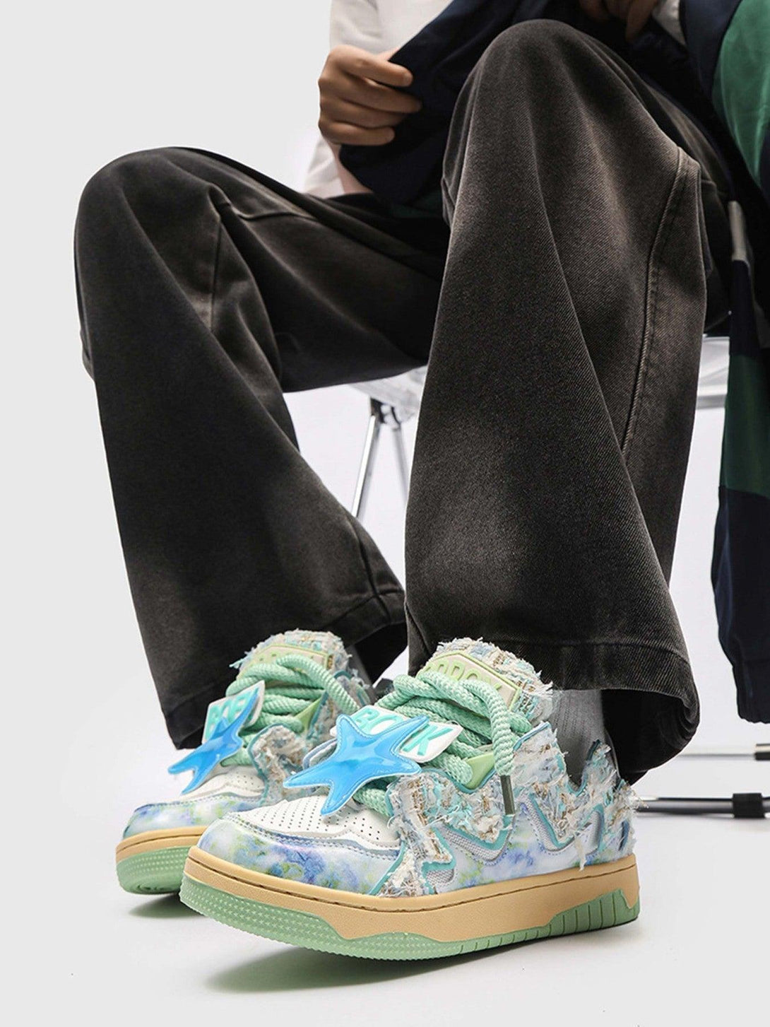 TALISHKO sneakers with blue star accents and pastel patterns, styled with wide-leg pants.