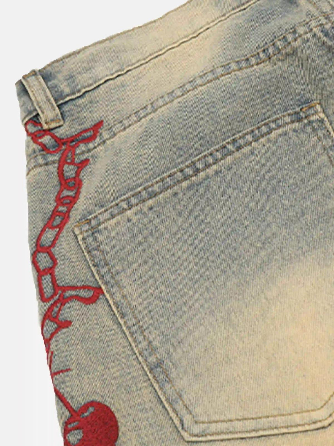 A detailed view of TALISHKO jeans' back pocket with red chain embroidery, adding hip-hop flair.