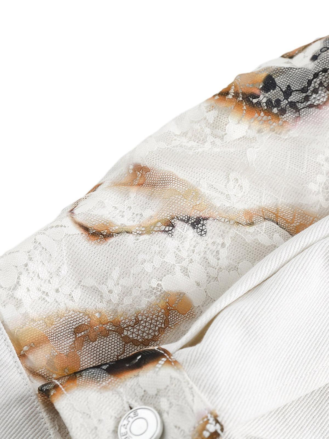 Intricate lace patchwork on TALISHKO's denim jacket sleeve, highlighting detailed craftsmanship.