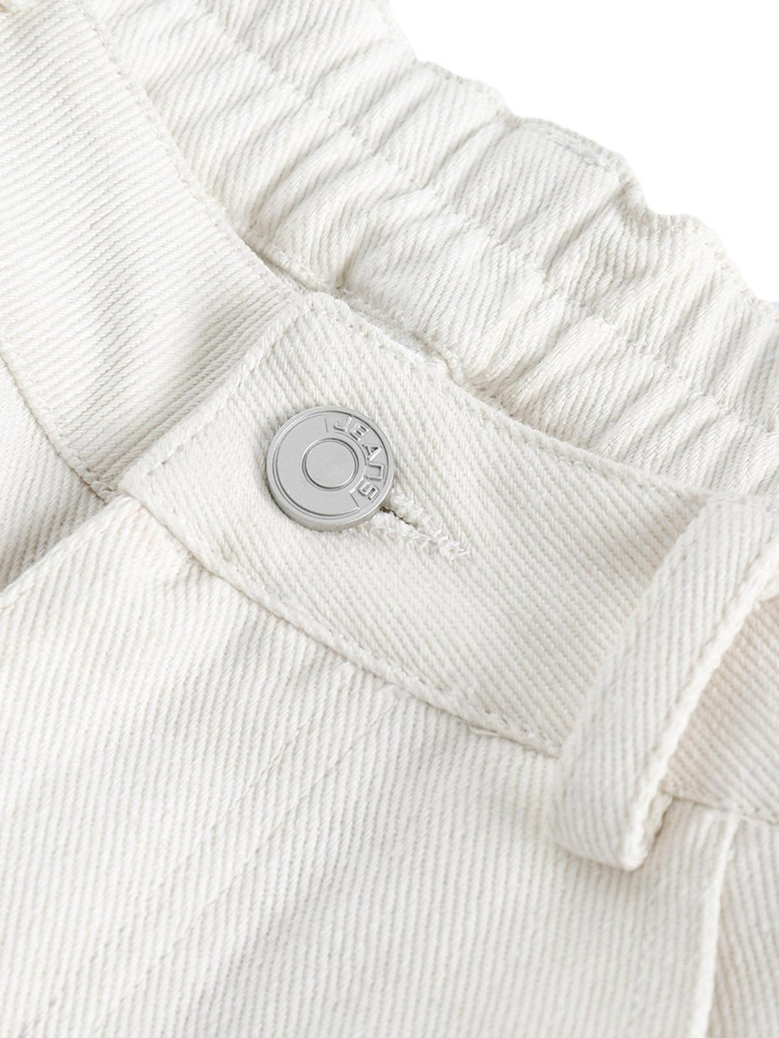 Detailed view of TALISHKO's white jeans button and elastic waistband, highlighting retro style.