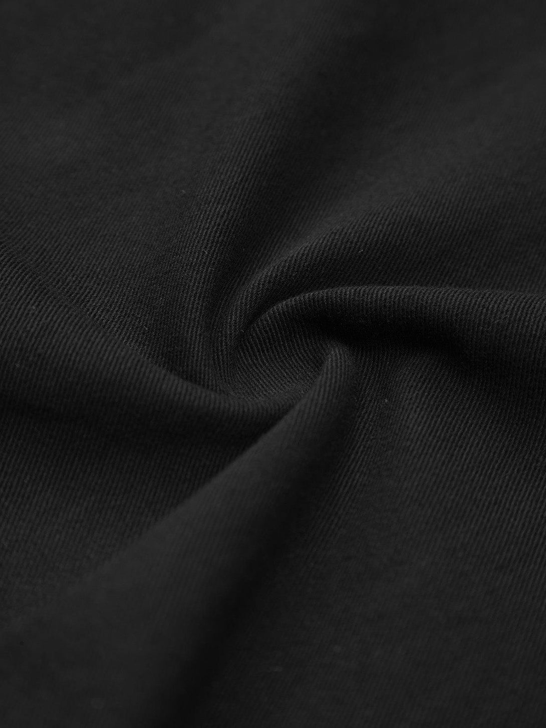 Zoomed-in texture of a black TALISHKO shirt fabric, highlighting its smooth and durable weave.