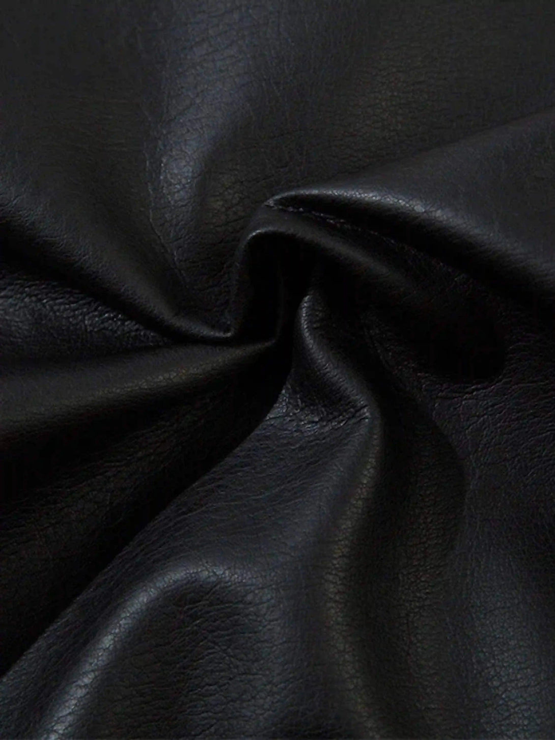 A close-up view of TALISHKO's black leather texture, emphasizing its rich, smooth finish.